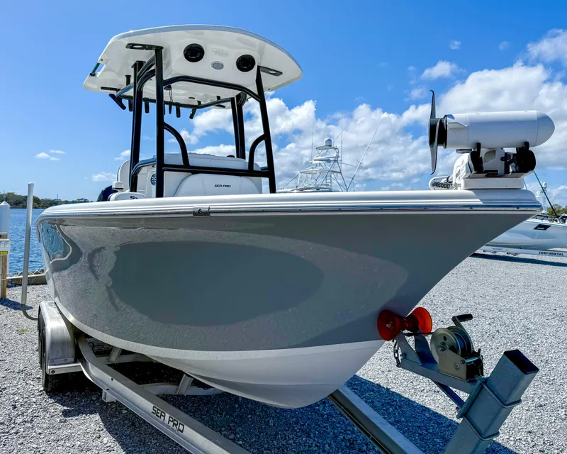 Slide: The Image of 2023 Sea Pro 219 Center Console boat on trailer, under clear blue sky. - 13