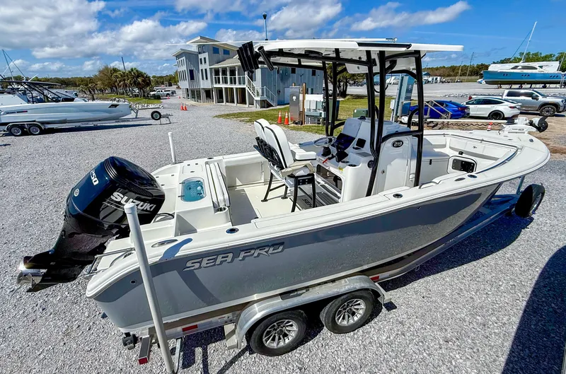 Slide: The Image of 2023 Sea Pro 219 Center Console boat on trailer, parked outdoors under blue sky. - 2