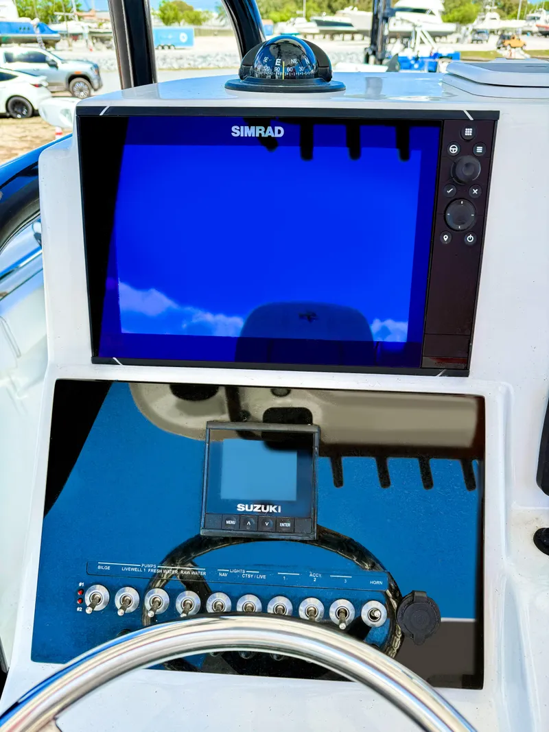 Slide: The Image of 2023 Sea Pro 219 Center Console dashboard with Simrad and Suzuki displays. - 8
