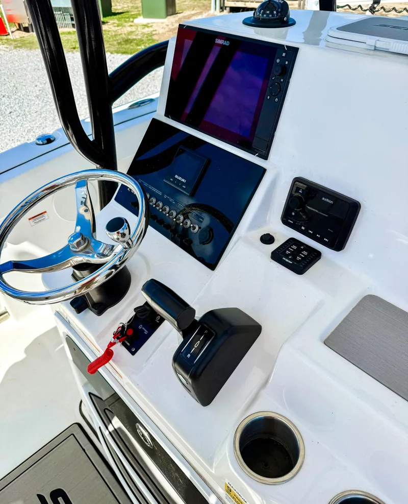 Slide: The Image of 2023 Sea Pro 219 Center Console boat dashboard with steering wheel and navigation controls. - 9
