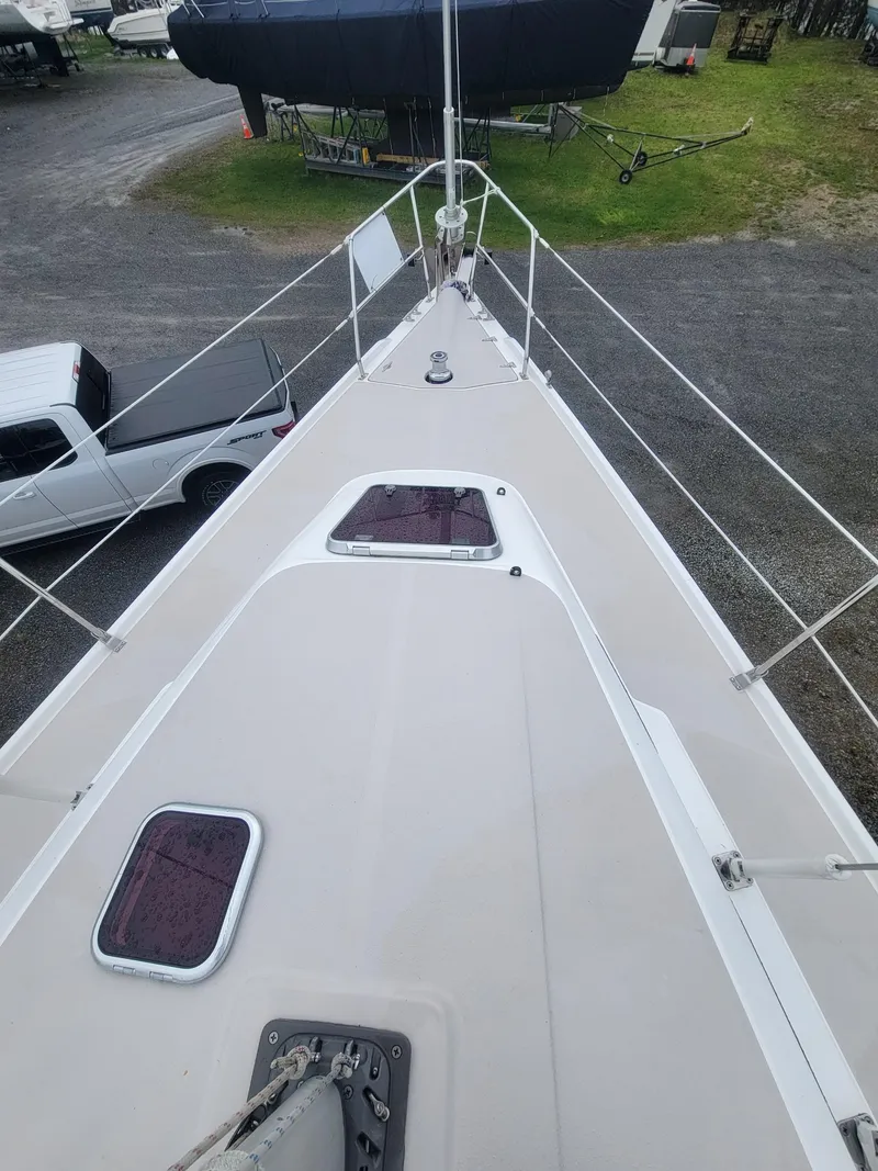 Slide: The Image of 2010 Catalina 350 sailboat deck view with hatches and railing in a marina setting. - 15