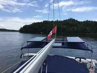 Slide: The Image of Catalina 350 sailboat on a serene lake with solar panels and a flag, 2010 model. - 2