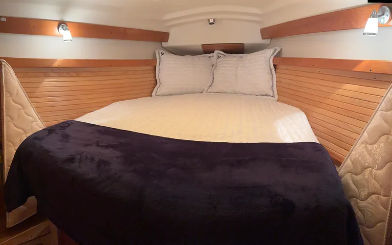 Slide: The Image of Cozy cabin interior of 2010 Catalina 350 sailboat with wood paneling and comfortable bedding. - 24