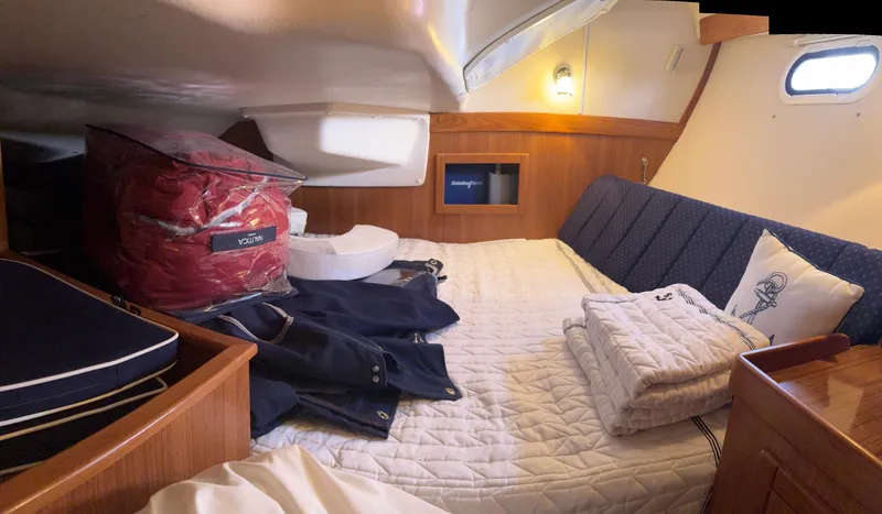 Slide: The Image of Cozy cabin interior of a 2010 Catalina 350 sailboat with bedding and storage. - 26