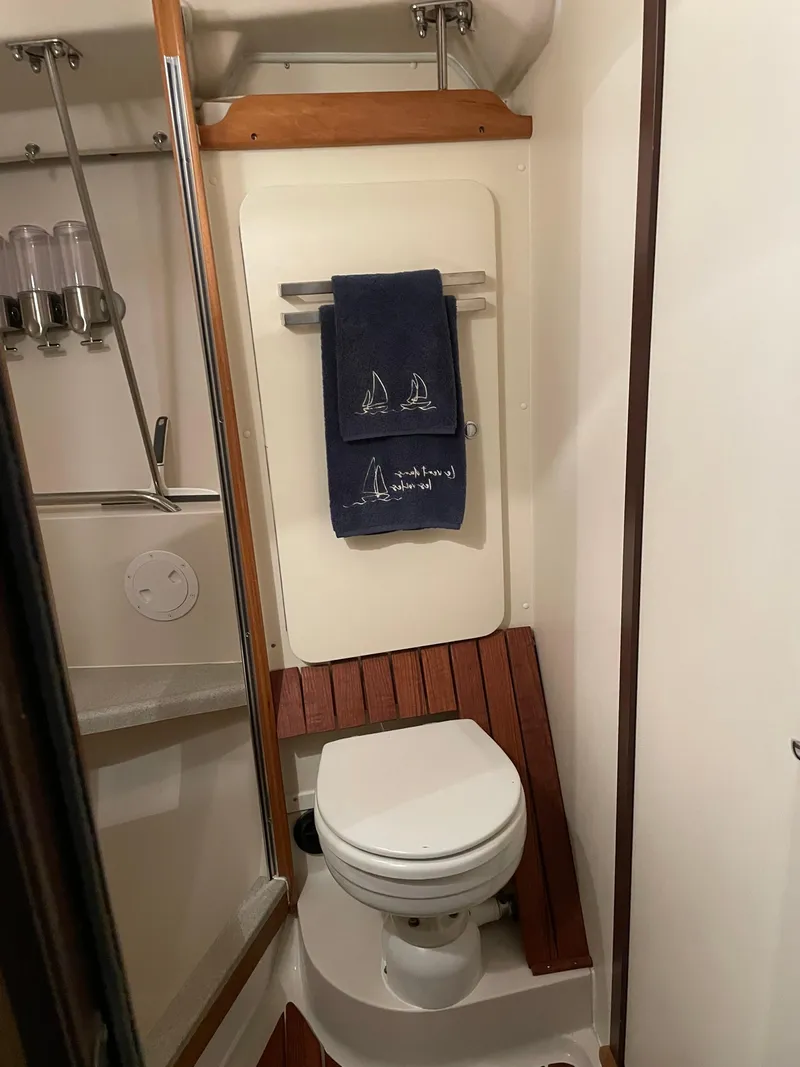 Slide: The Image of Compact bathroom in a 2010 Catalina 350 sailboat with wooden accents and nautical-themed towel. - 29