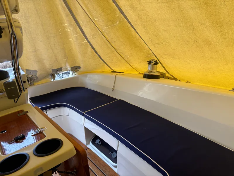 Slide: The Image of Interior view of a 2010 Catalina 350 sailboat with blue seating and a yellow canopy. - 8