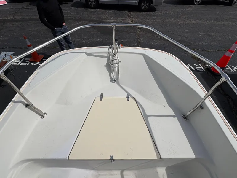 Slide: The Image of 1984 Boston Whaler 170 Super Sport boat deck with railing and storage compartment. - 12