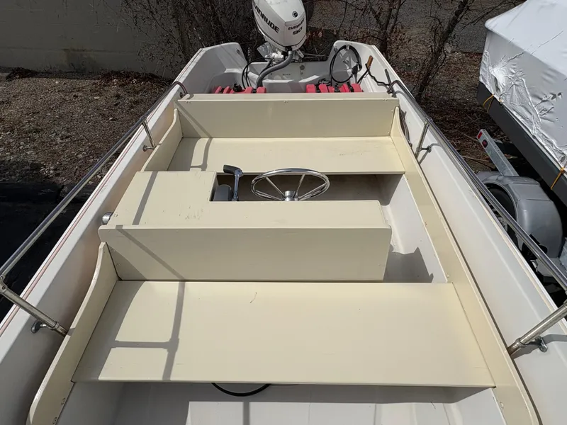 Slide: The Image of 1984 Boston Whaler 170 Super Sport boat interior with steering wheel and outboard motor. - 6