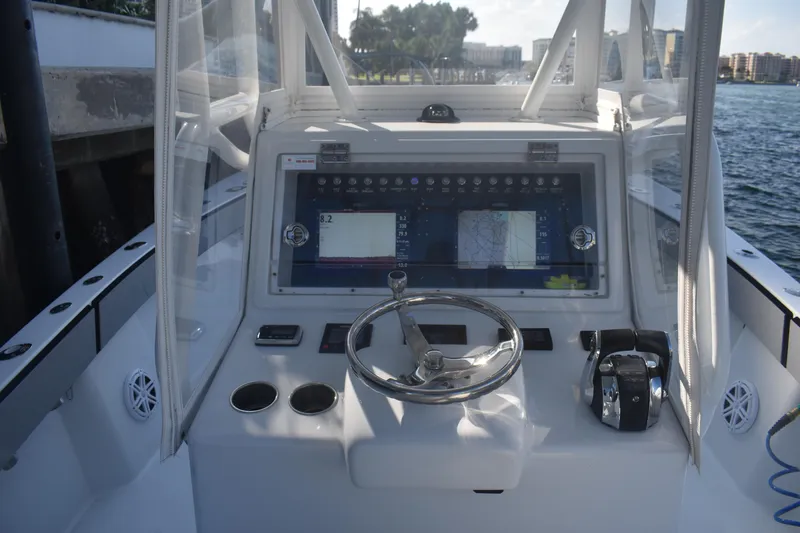 Slide: The Image of 2017 Conch 30 boat helm with steering wheel, navigation display, and controls. - 12