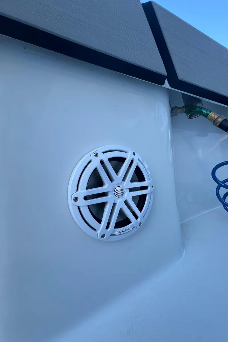 Slide: The Image of 2017 Conch 30 boat speaker with white grille and blue hose in background. - 17