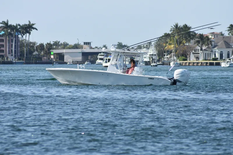 Slide: The Image of 2017 Conch 30 boat cruising on a sunny day near waterfront homes. - 19