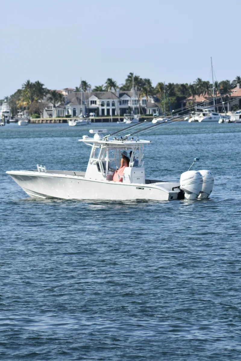 Slide: The Image of 2017 Conch 30 boat cruising on a sunny day near waterfront homes. - 21