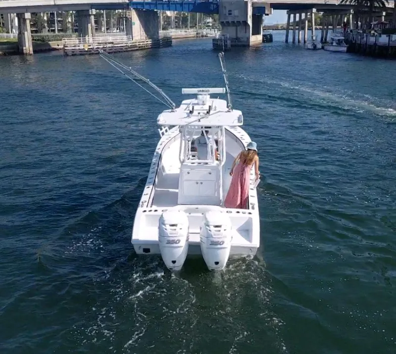Slide: The Image of 2018 Conch 30 boat cruising under a bridge with a person on deck. - 6
