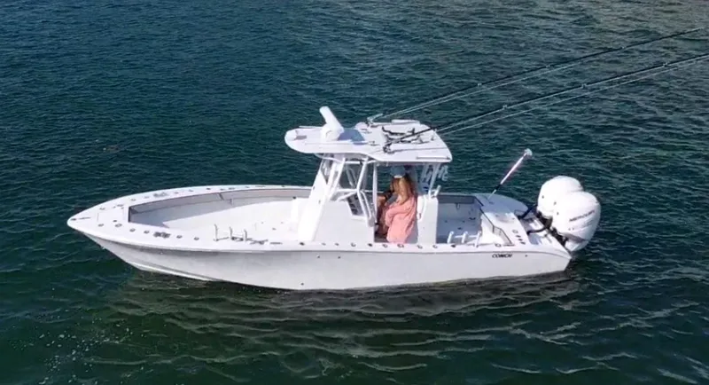 Slide: The Image of 2018 Conch 30 boat on water with dual engines and a person at the helm. - 8