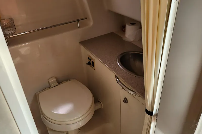 Slide: The Image of 2007 Sea Ray 290 Sundancer bathroom with toilet, sink, and countertop. - 11