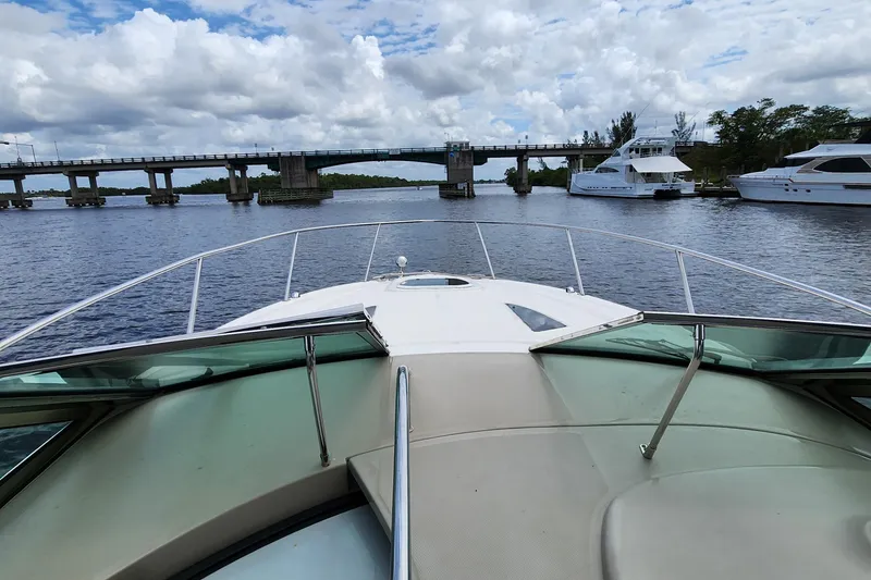 Slide: The Image of 2007 Sea Ray 290 Sundancer cruising near a bridge with yachts in the background. - 12
