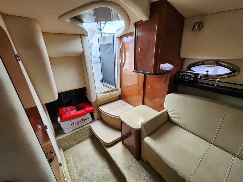 Slide: The Image of 2007 Sea Ray 290 Sundancer cabin interior with beige seating and wooden cabinetry. - 4
