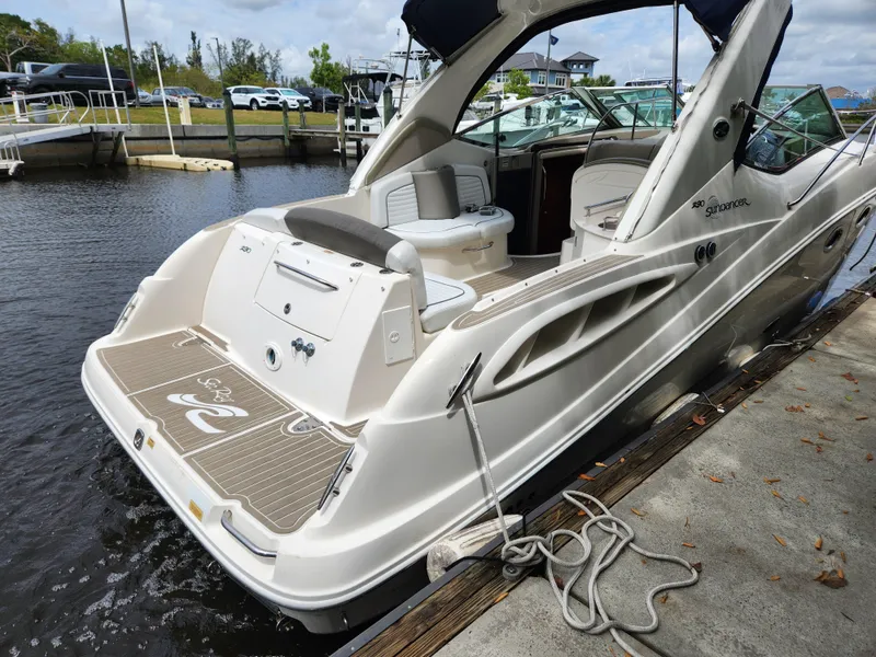Slide: The Image of 2007 Sea Ray 290 Sundancer docked at marina, showcasing sleek design and spacious deck. - 7