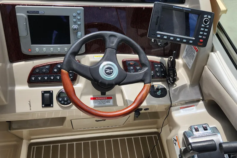 Slide: The Image of 2007 Sea Ray 290 Sundancer helm with steering wheel and navigation controls. - 8