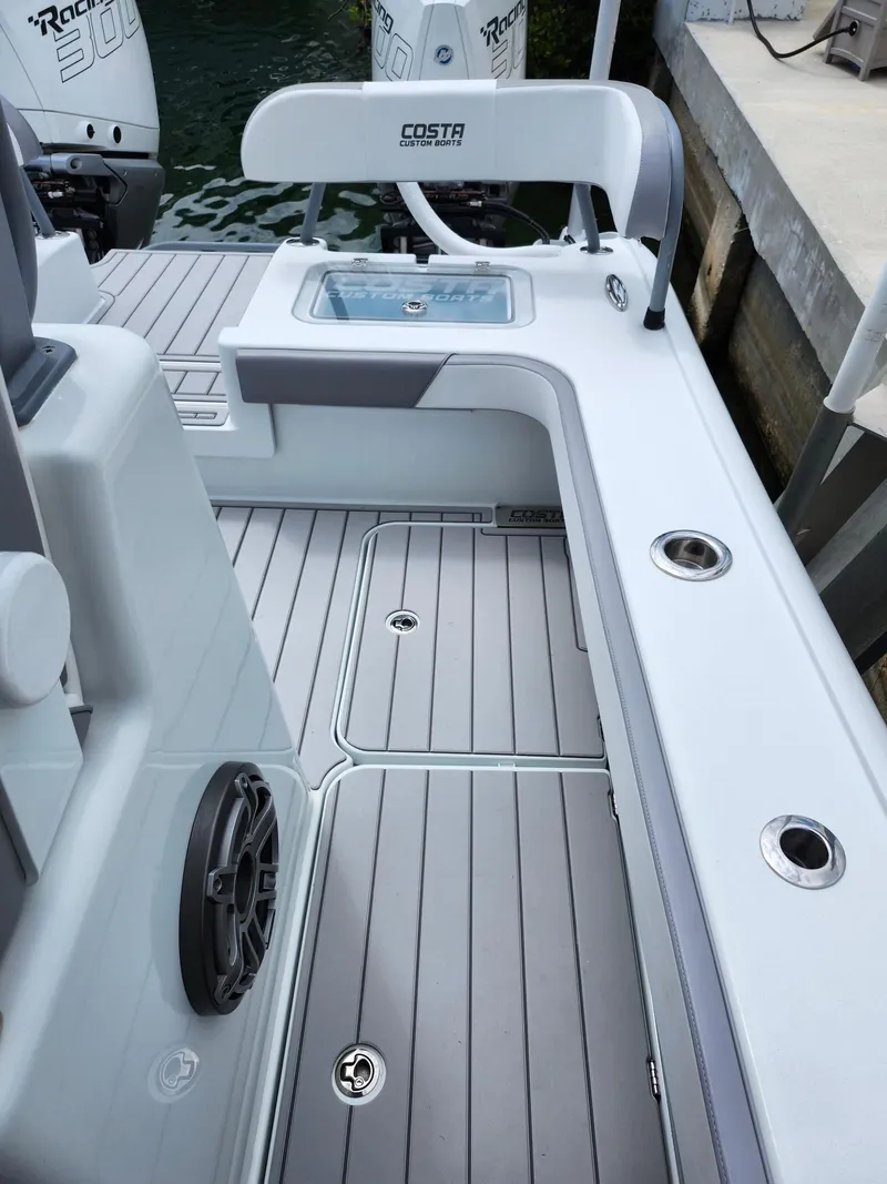 Slide: The Image of 2022 Costa Custom Boats 264 HC deck with seating and storage features. - 13
