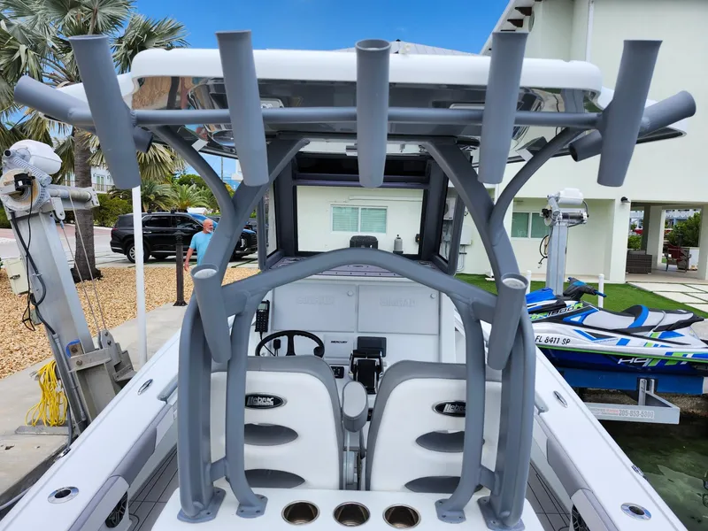 Slide: The Image of 2022 Costa Custom Boats 264 HC with rod holders and dual seats, docked near a house. - 17