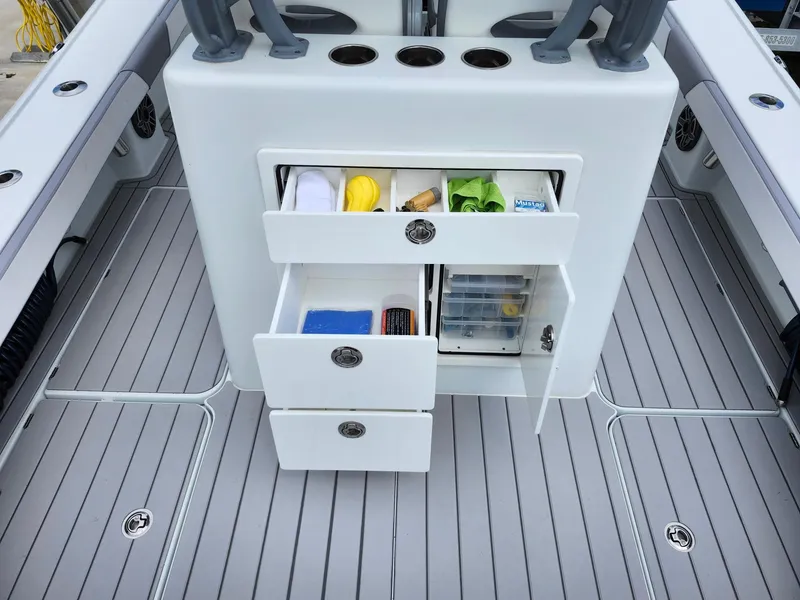 Slide: The Image of 2022 Costa Custom Boats 264 HC interior with storage drawers and fishing gear. - 18
