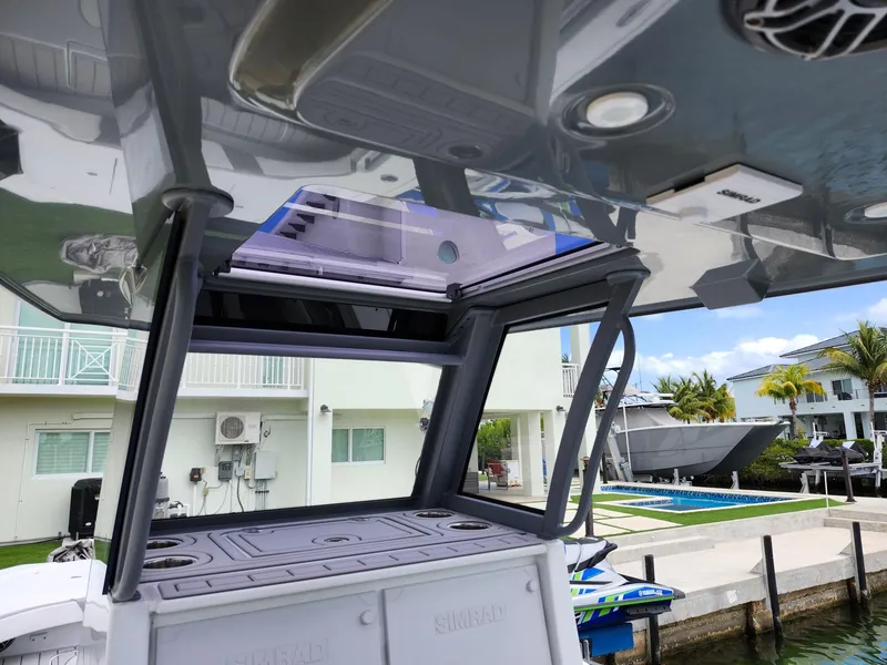Slide: The Image of 2022 Costa Custom Boats 264 HC with sleek design, docked near waterfront homes. - 21