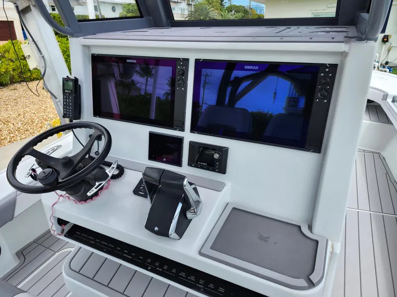 Slide: The Image of 2022 Costa Custom Boats 264 HC helm with dual displays and steering wheel. - 24