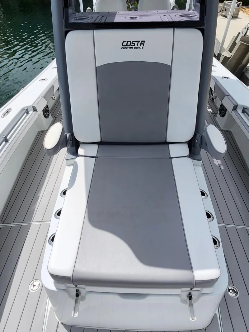 Slide: The Image of 2022 Costa Custom Boats 264 HC seating area with gray and white upholstery. - 9