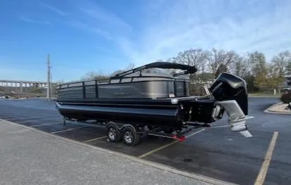 Slide: The Image of 2024 Regency 250 LE3 boat with Mercury outboard motor, parked near a scenic lake. - 3