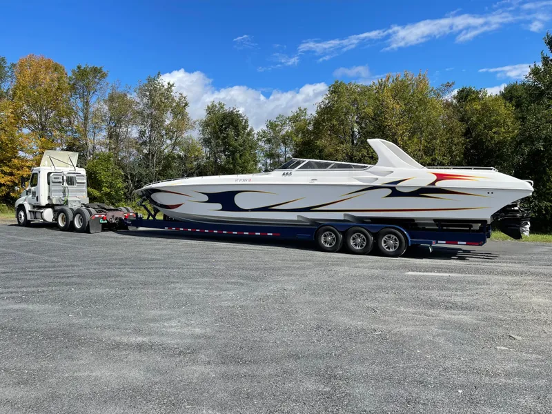 Slide: The Image of 2005 Fountain 47 Lightning boat on trailer, parked outdoors with trees in the background. - 2