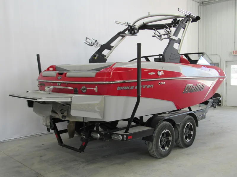 Slide: The Image of 2019 Malibu Wakesetter 20 VTX boat in a garage, red and white design. - 2