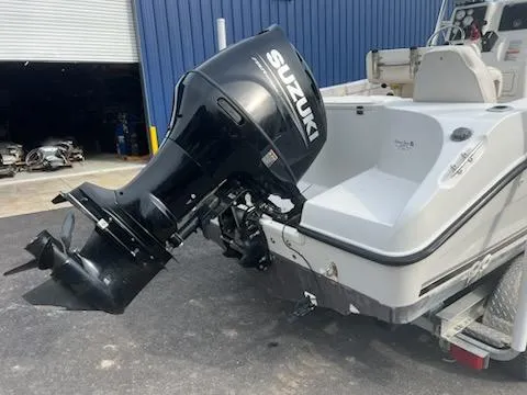 Slide: The Image of 2001 Seaswirl Striper 2101 Center Console with Suzuki outboard motor, parked near a blue building. - 3