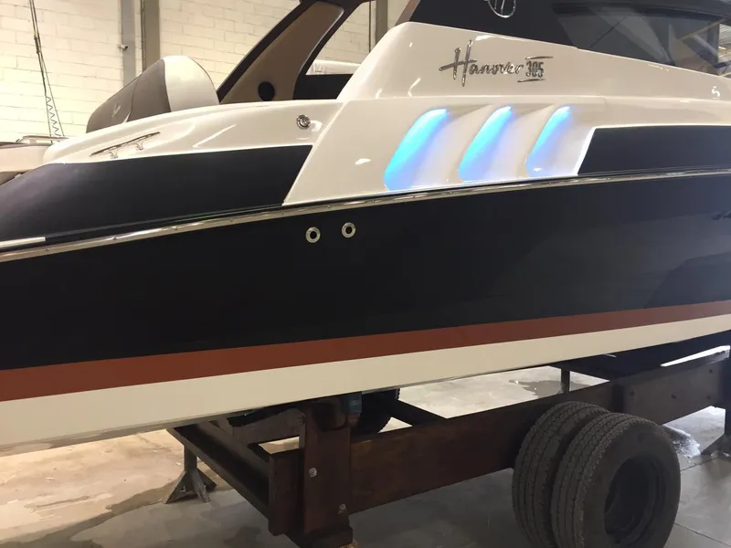 Slide: The Image of 2025 Hanover 305 boat with sleek design and illuminated accents in a workshop setting. - 3
