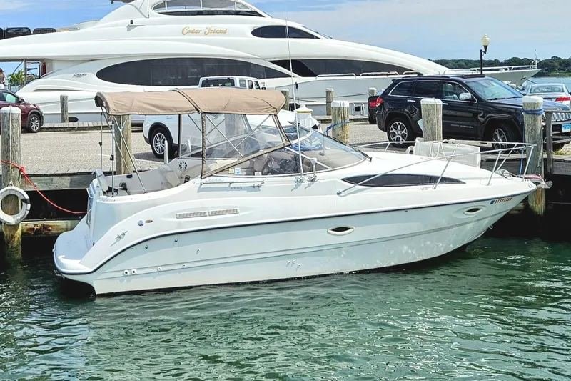 Slide: The Image of 2001 Bayliner 2655 Cierra boat docked at marina with luxury yacht in background. - 1