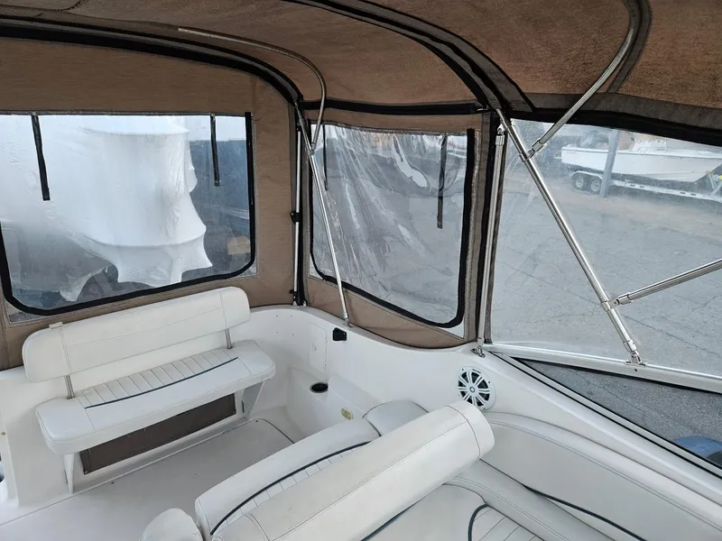 Slide: The Image of Interior view of a 2001 Bayliner 2655 Cierra boat with beige canopy and white seating. - 13