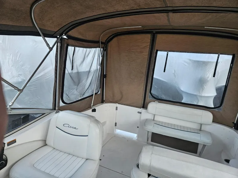 Slide: The Image of 2001 Bayliner 2655 Cierra boat interior with white seating and enclosed canopy. - 15