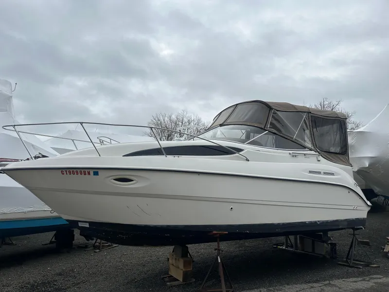 Slide: The Image of 2001 Bayliner 2655 Cierra boat on stands, under cloudy sky. - 2