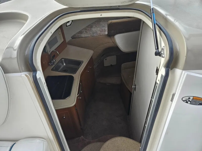 Slide: The Image of Interior view of 2001 Bayliner 2655 Cierra boat, featuring compact kitchen and seating area. - 23