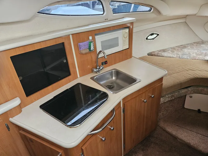 Slide: The Image of 2001 Bayliner 2655 Cierra cabin interior with kitchenette, sink, and microwave. - 26