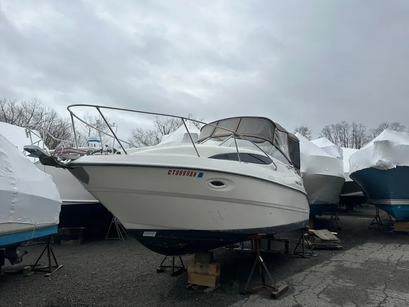Slide: The Image of 2001 Bayliner 2655 Cierra boat on stands, covered, in a storage yard. - 3