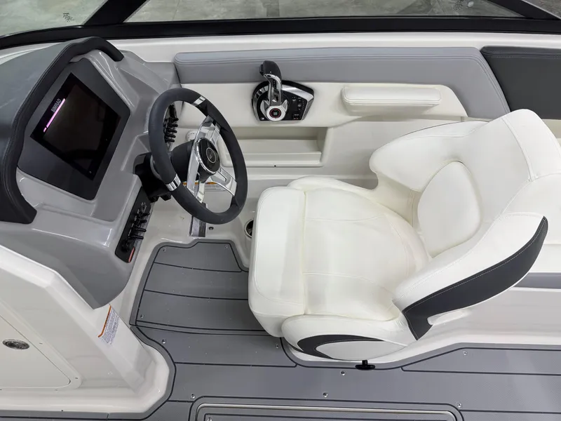 Slide: The Image of 2025 Chaparral 23 SSi boat interior with steering wheel and white captain's seat. - 15