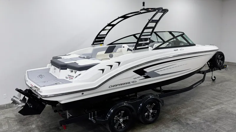 Slide: The Image of 2025 Chaparral 23 SSi boat on trailer, sleek design, white exterior, modern features. - 2