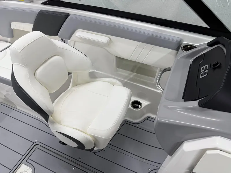 Slide: The Image of 2025 Chaparral 23 SSi boat interior with white seating and modern dashboard design. - 20