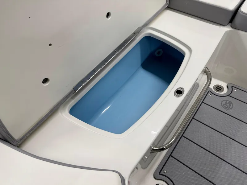 Slide: The Image of 2025 Chaparral 23 SSi boat storage compartment with blue interior and gray flooring. - 22