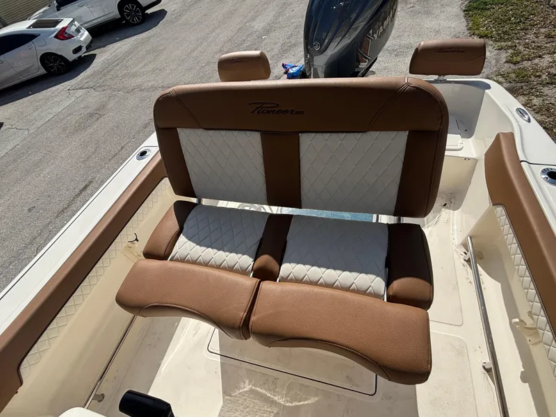 Slide: The Image of 2025 Pioneer 202 Sportfish boat interior with brown and white cushioned seating. - 11