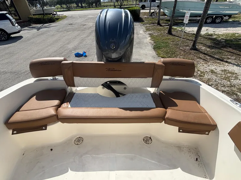 Slide: The Image of 2025 Pioneer 202 Sportfish boat with brown seating and outboard motor in a sunny outdoor setting. - 13
