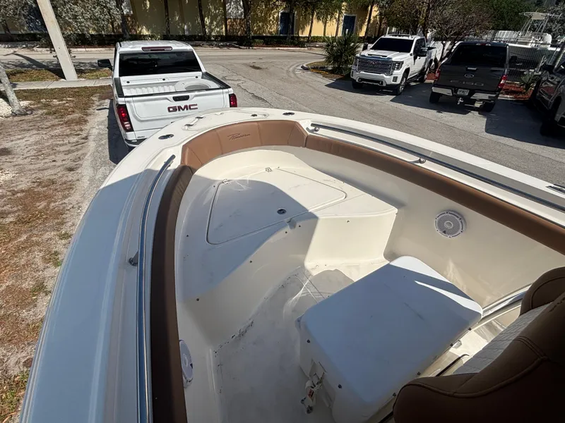 Slide: The Image of 2025 Pioneer 202 Sportfish boat interior with seating, parked near GMC truck. - 5