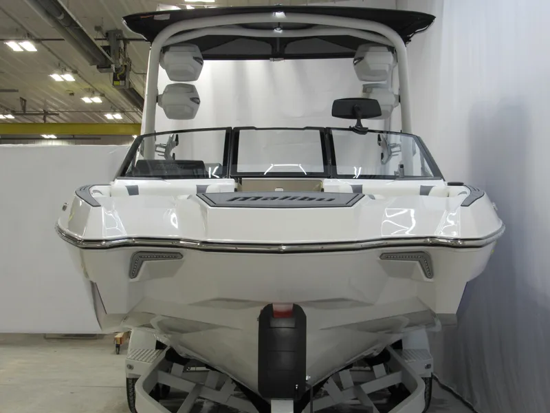 Slide: The Image of 2025 Malibu Wakesetter 24 MXZ boat, front view, in a showroom setting. - 1