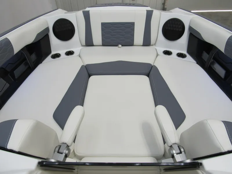 Slide: The Image of 2025 Malibu Wakesetter 24 MXZ interior, featuring sleek white and gray seating with cup holders. - 9
